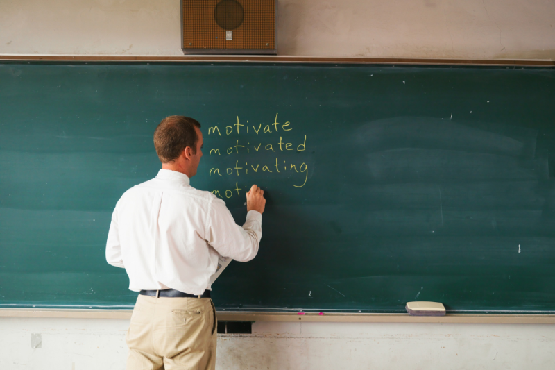 profesor scriind pe tabla de scris cu creta profesor scriind pe tabla de scris cu creta