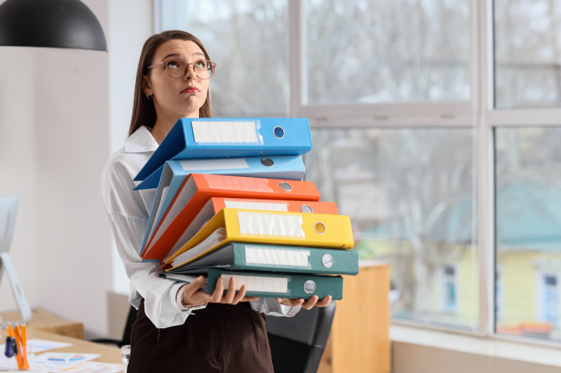 secretara tinand in brate bibliorafturi pentru arhivare documente secretara tinand in brate bibliorafturi pentru arhivare documente