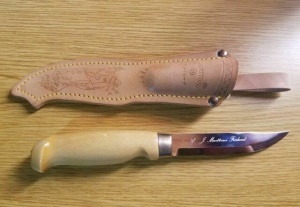 Cutit Marttiini Lynx 129 cu lama inox de 110mm si maner din mesteacan lacuit, livrat cu teaca din piele.