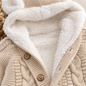 Combinezon bebe tricotat premium cu interior imblanit, gluga cu urechiuse si model impletit crem, prezentare in decor