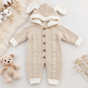 Salopeta bebe pentru iarna bej tricotata cu interior imblanit, gluga cu urechiuse si model torsadat, prezentare in decor
