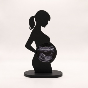 Statuetă neagră fotografiată din față, pe fundal neutru deschis, stil studio