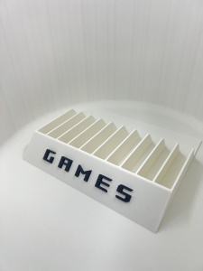 Organizator jocuri PS4 PS5 Xbox alb, vedere din unghi lateral, sloturi verticale si inscriptia GAMES vizibila