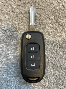 carcasa cheie Dacia Renault 3 butoane fotografiata pe fundal texturat