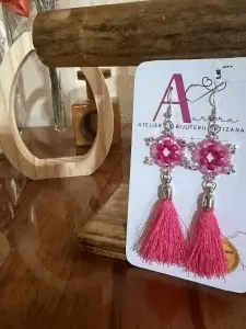 Descoperă cerceii handmade Fucsia Vibrant din Colecția Ciucuri, realizați cu mărgele roz, accente argintii și ciucuri fini în nuanțe intense.