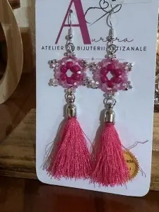 Descoperă cerceii handmade Fucsia Vibrant din Colecția Ciucuri, realizați cu mărgele roz, accente argintii și ciucuri fini în nuanțe intense.