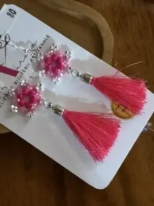 Descoperă cerceii handmade Fucsia Vibrant din Colecția Ciucuri, realizați cu mărgele roz, accente argintii și ciucuri fini în nuanțe intense.