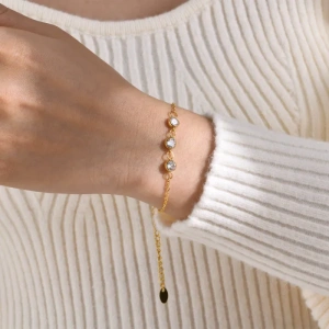 Detaliu bratara delicata aurie cu cristal zirconiu rotund purtata la incheietura