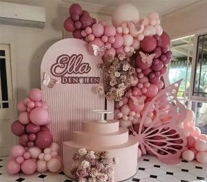 Prezentare eleganta pentru un set arcada baloane aniversare Rose Gold si Burgundy, montat asimetric intr-un decor rafinat cu baloane ivory si roz pal.