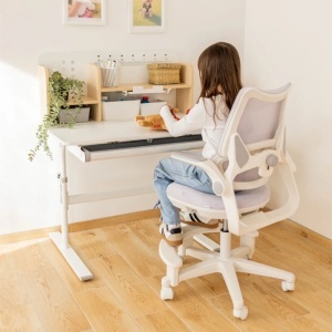Devojčica sedi na ergonomskoj dečijoj stolici Mark Adler Junior 5.7 Purple i uči za stolom