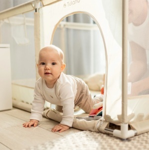 Beba puzi i bezbedno se igra unutar bež ogradice za igru Tulano Cozy 20 Beige