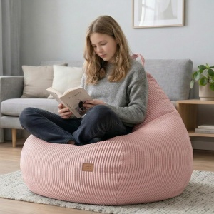 Devojčica čita knjigu sedeći na udobnom roze lejzi begu Mark Adler Comfy 1.0 Pink