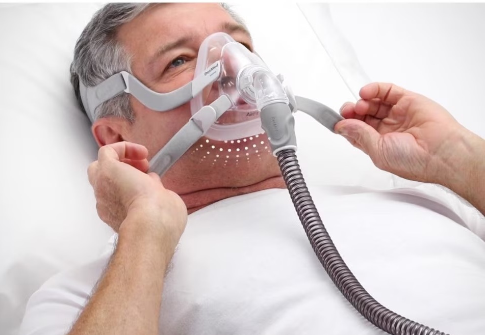 adaptare CPAP - pacient care isi potriveste masca inainte de culcare