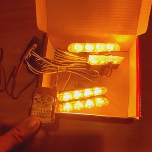 Set de 4 stroboscoape LED galbene în funcționare, cu lumină puternică și control prin telecomandă pentru montaj pe auto, ATV sau utilaje.