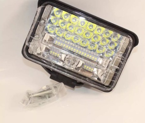 Proiector LED off-road livrat cu accesorii de montaj, pregătit pentru instalare pe vehicule de teren și utilaje.