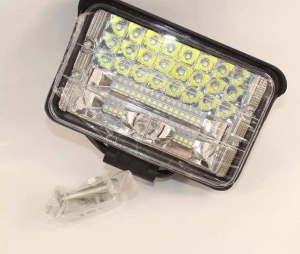 Proiector LED off-road livrat cu accesorii de montaj, pregătit pentru instalare pe vehicule de teren și utilaje.