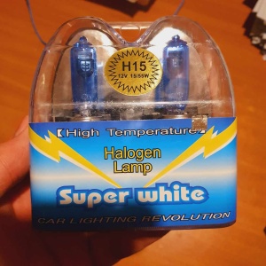 Ambalajul setului de becuri halogen H15 12V 55W evidențiază tipul soclului și aspectul super white al luminii.