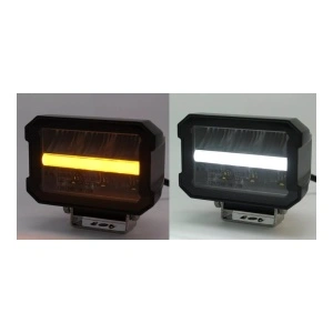 Proiector auto LED universal în funcționare, cu lumină albă și lumină portocalie pentru semnalizare.