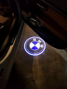 Proiecție logo BMW pe sol la deschiderea portierei, pentru un efect premium și vizibil pe timp de noapte.