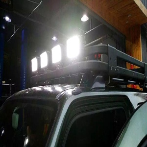 Proiectoare LED 48W pătrate montate pe bara de plafon a unui autoturism, utilizate pentru iluminare suplimentară pe timp de noapte.