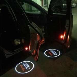 Proiecție Audi pe sol la deschiderea portierelor, surprinsă pe timp de noapte, pentru evidențierea efectului luminos în utilizare reală.