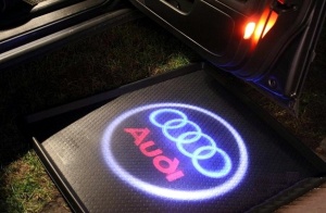 Logo Audi proiectat clar pe sol lângă portieră, ideal pentru un plus de stil și iluminare la deschiderea ușii.